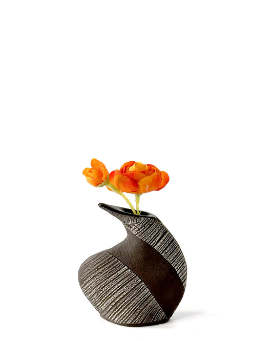 Black and gray textured vase with orange flowers on a white background